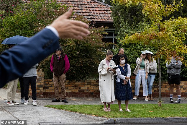 Melbourne was the worst performing property market in Australia's capital in 2024, despite receiving a large influx of foreign migrants (pictured, an auction in Melbourne)