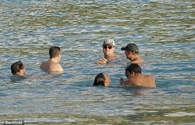 Leo was spotted chatting with friends in the surf