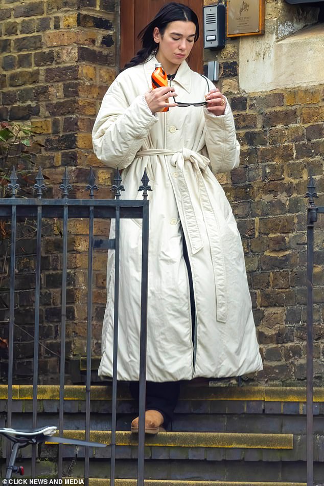 The pop star bundled up for the outing in a white trench coat that she wore with black pants and a pair of tan UGG boots.