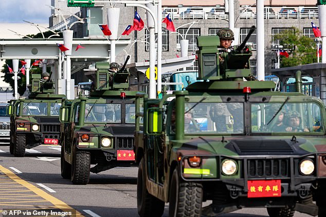 Armed military vehicles patrol outside Songshan Airport in Taipei after China deployed fighter jets and warships to encircle Taiwan on October 14, in exercises that Beijing said were aimed at sending a 