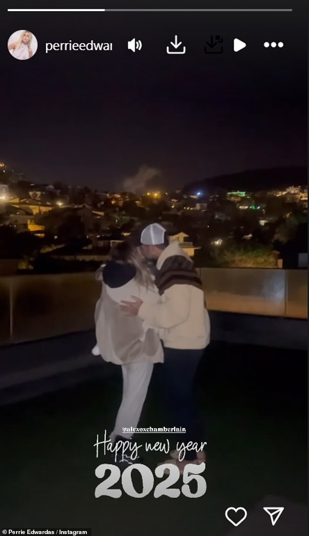 Perrie Edwards rang in the new year by sharing a sweet kiss with her fiancé Alex Oxlade-Chamberlain and son Axel while watching fireworks on a rooftop.