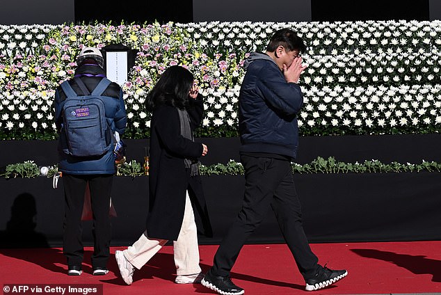 Mourners react as they pay their respects at a memorial altar for the victims of the Jeju Air plane crash.