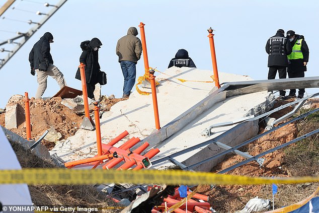 Investigators, including officials from South Korea's Aviation and Railroad Accident Investigation Board (ARAIB), the US National Transportation Safety Board (NTSB) and aircraft manufacturer Boeing, stand next to the mound where the instrument landing system locator is located, in the place where the Jeju Air Boeing 737 was located. -800 planes crashed