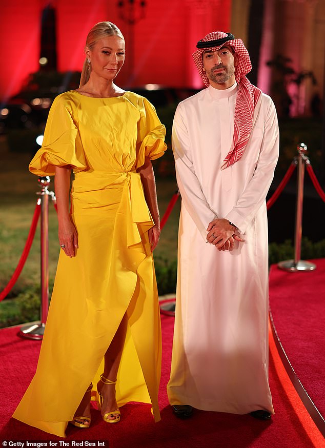 She paired the piece with a pair of barely-there yellow heels and accessorized them with chandelier earrings (pictured with Saudi Arabian film producer Mohammed Al Turki).