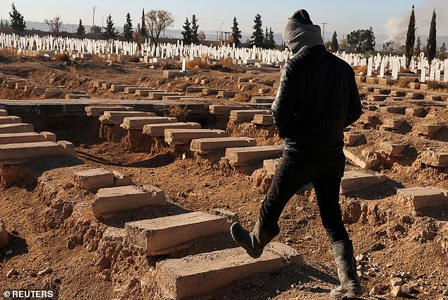 A Tadamon local walks past the site of a mass grave belonging to Bashar al-Assad's government in Syria.