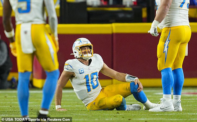 Chargers quarterback Justin Herbert (10) reacts after an injury during the first half