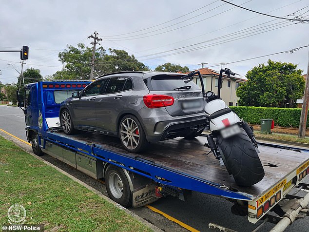 A vehicle and a motorcycle are towed after the Thursday morning raids.