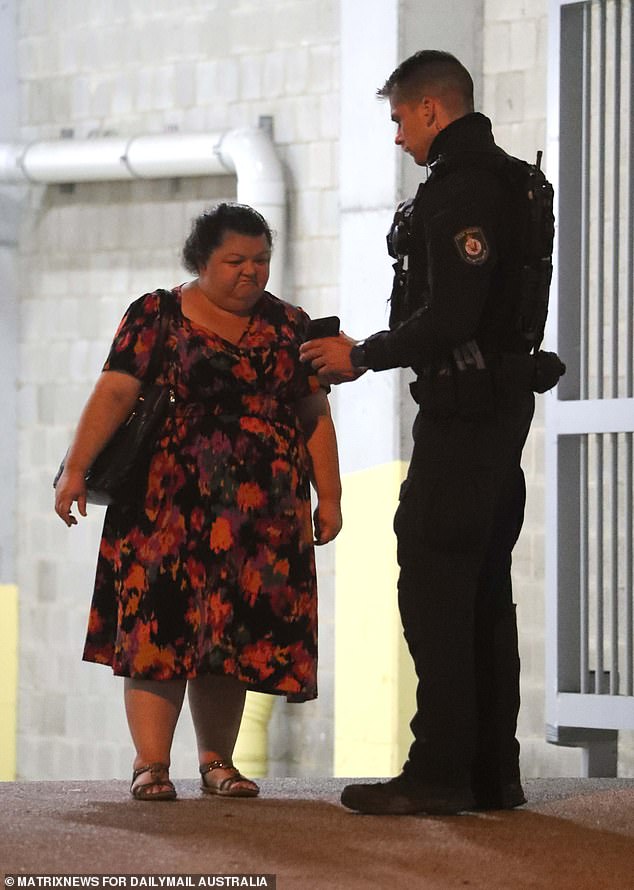 Police officers were seen showing the image to residents of the apartment building (pictured).