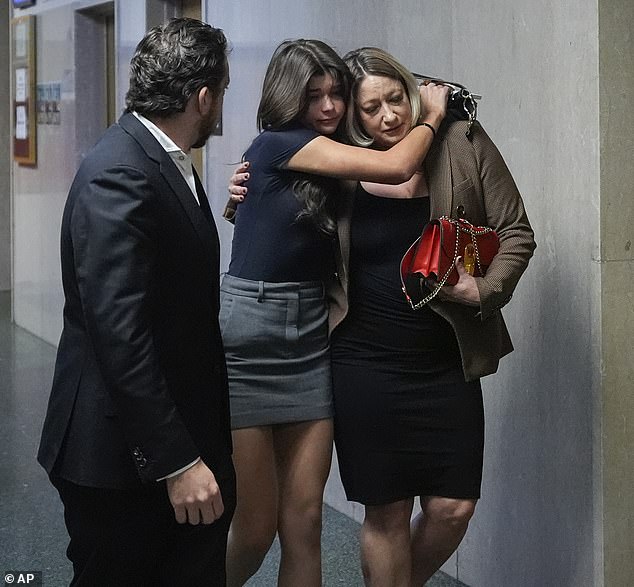 Scout Lee, Bob Lee's daughter, seen with her arms wrapped around her mother Krista Lee, right, with Tim Oliver Lee (Bob's brother) at the Hall of Justice for the murder trial of Nima Momeni in San Francisco on Monday