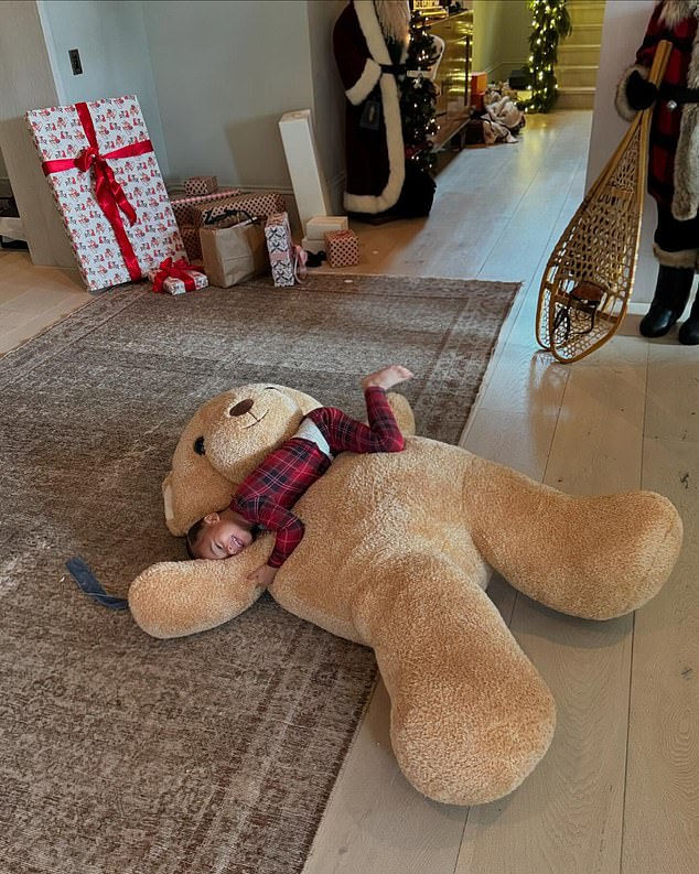 In another photo of the baby, Aire flashed a sweet smile while lying on a giant brown teddy bear in the foyer of Jenner's $60 million Hidden Hills mansion.