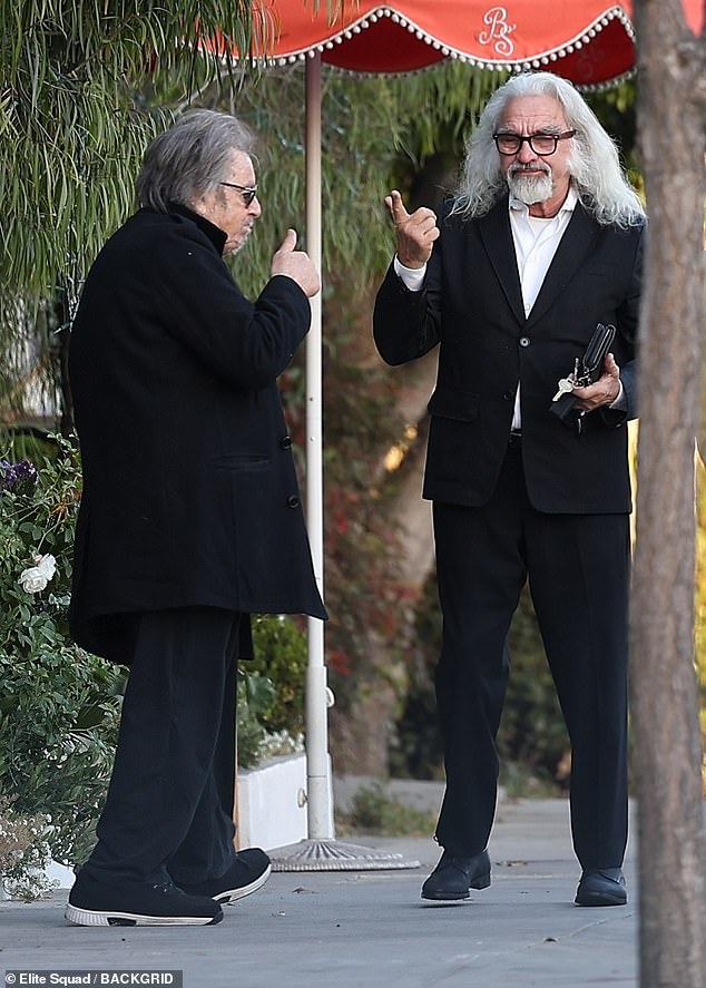 Meanwhile, George cut a dashing figure in a crisp white shirt and black suit jacket, his trademark long white hair turning heads among onlookers