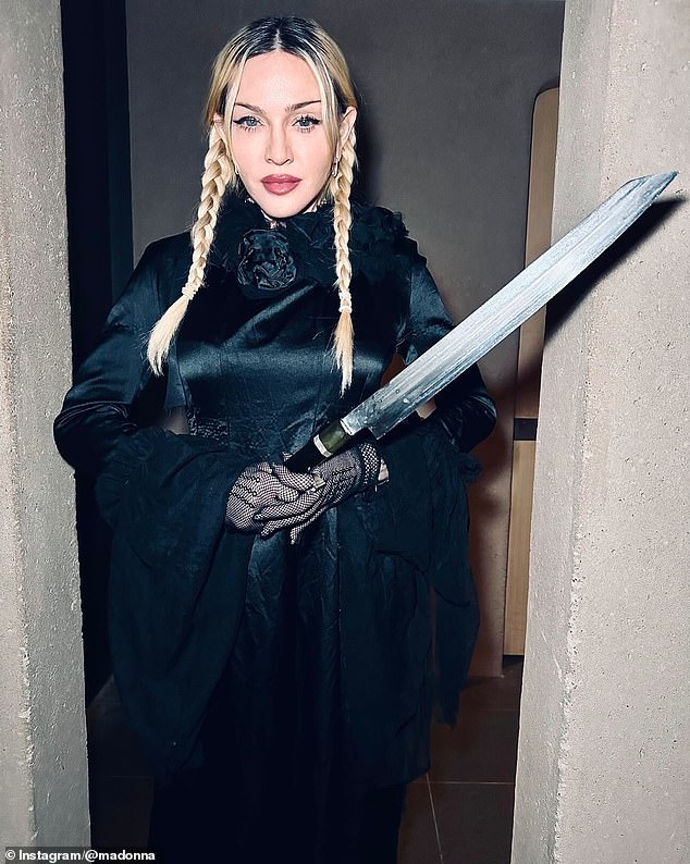 In one snap, she posed with a sword while modeling a long satin dress with fishnet gloves and her platinum blonde locks in braids.