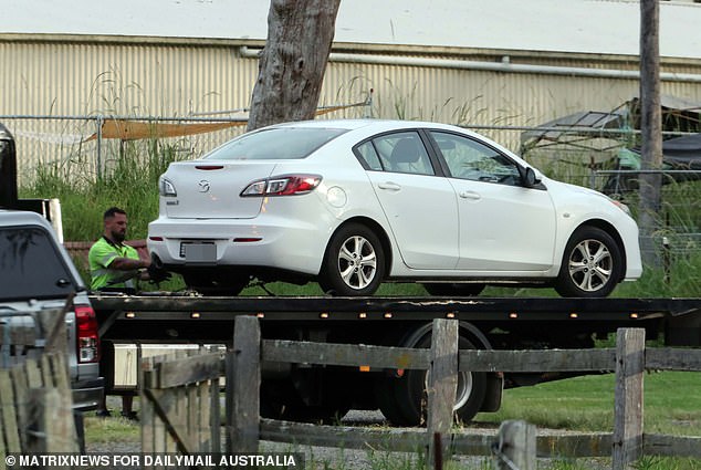 Shortly before 7 p.m., a flatbed truck took away a white Mazda sedan (pictured)