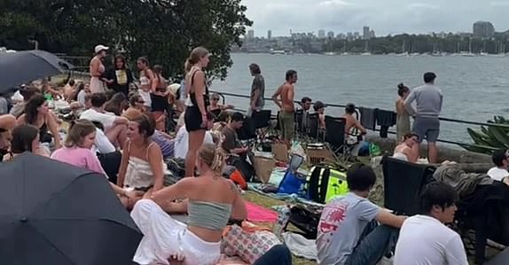 14238041 Chaotic moment: Massive crowds ignore New Year's Eve rules and rush to Sydney's best vantage points before fireworks