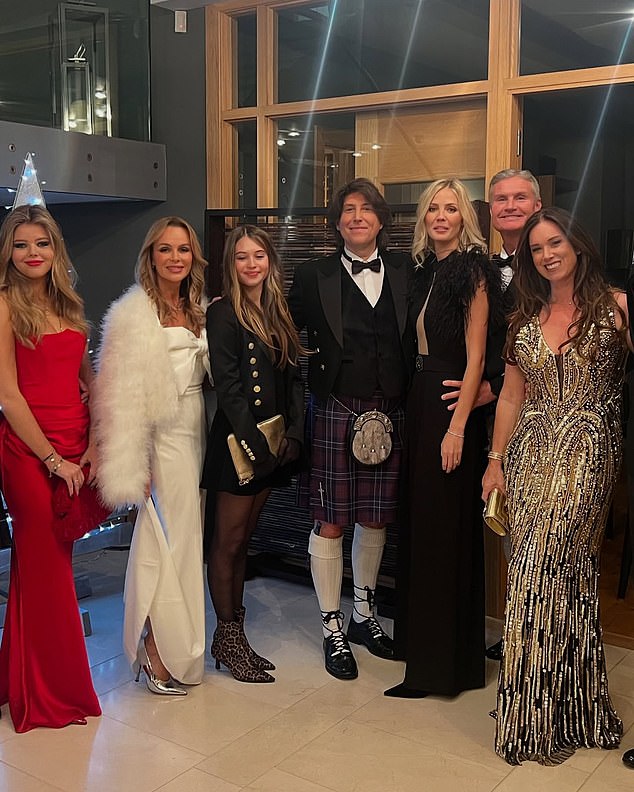 Amanda made sure all eyes were on her in a stunning white satin dress as she posed with husband Chris Hughes and twin daughters Lexi, 18, and Hollie, 13, and former Formula One driver David Coulthard.