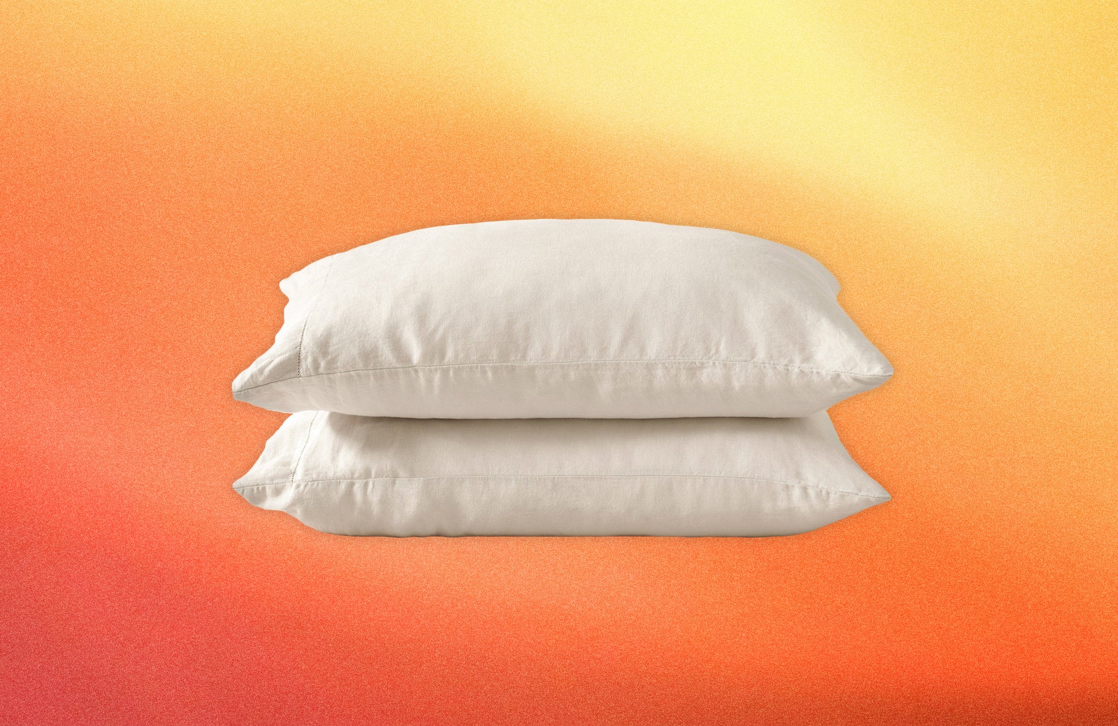 Stack of 2 white pillows on hazy orange and yellow texture background