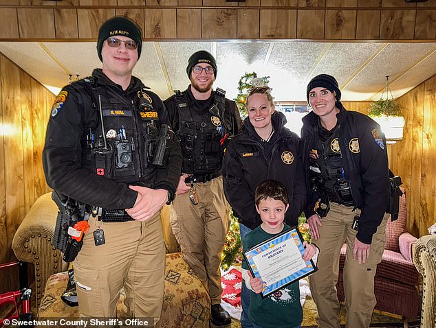 In the days following the harrowing incident, Sweetwater County police rewarded the brave and smart boy with a framed bravery certificate and goodie package. Pictured: Mason with his award alongside Deputies Nathaniel Hull and Zachary Otte, Detective Stephanie Cassidy and Deputy Ana Lindig