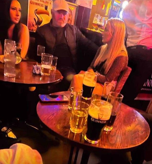 Rooney is seen sitting with a group of women during a night out at a pub.