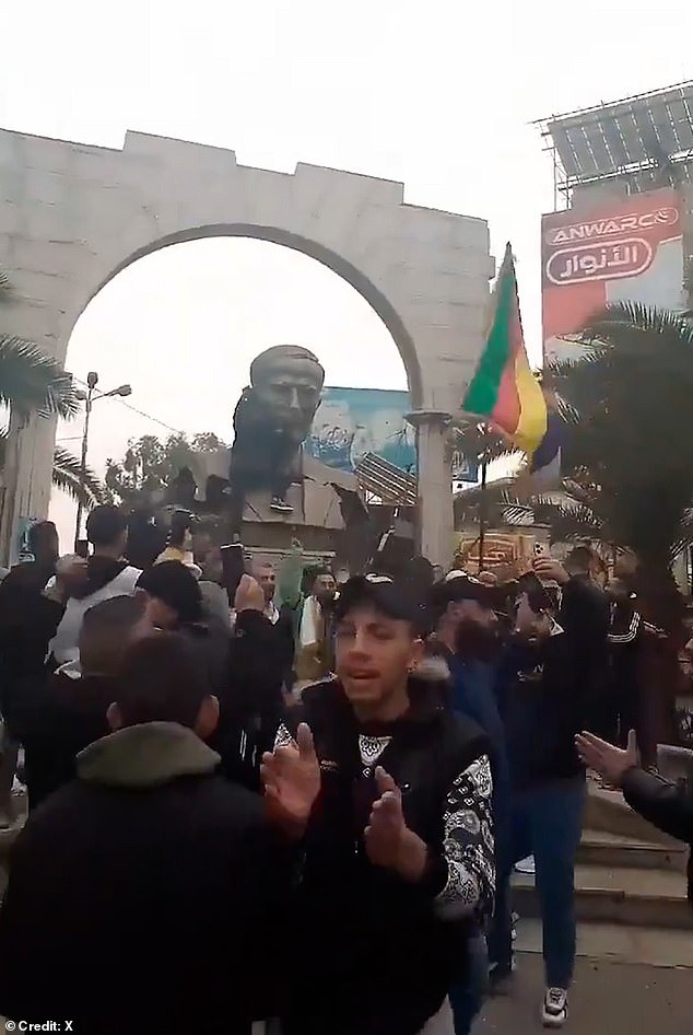 People in Damascus tear down a statue of Hafez al-Assad and wave a Druze flag as rebel forces approach the capital, December 7.