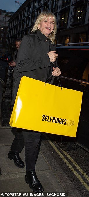 Completing the look with black boots she was seen smiling from ear to ear as she left the restaurant carrying a large Selfridges bag.