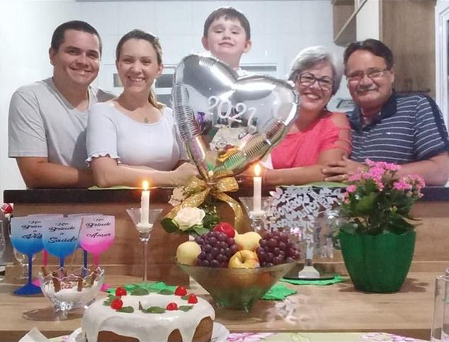 A photo found on Zeli's social media by MailOnline shows a similar white icing-covered fruitcake, topped with cherries, which she baked in 2021 and assembled with her husband Paulo (right, next to his wife) and other family members.