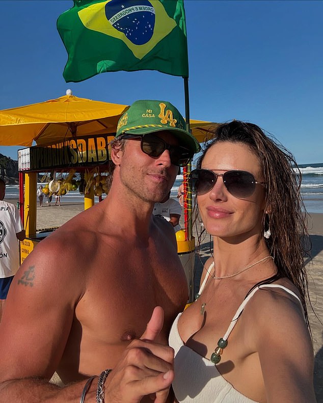 The Victoria's Secret model wore a textured white top with thin rhinestone straps and aviator sunglasses. Buck, an Australian jewelry designer, wore a green Good Quality Human hat and went shirtless.