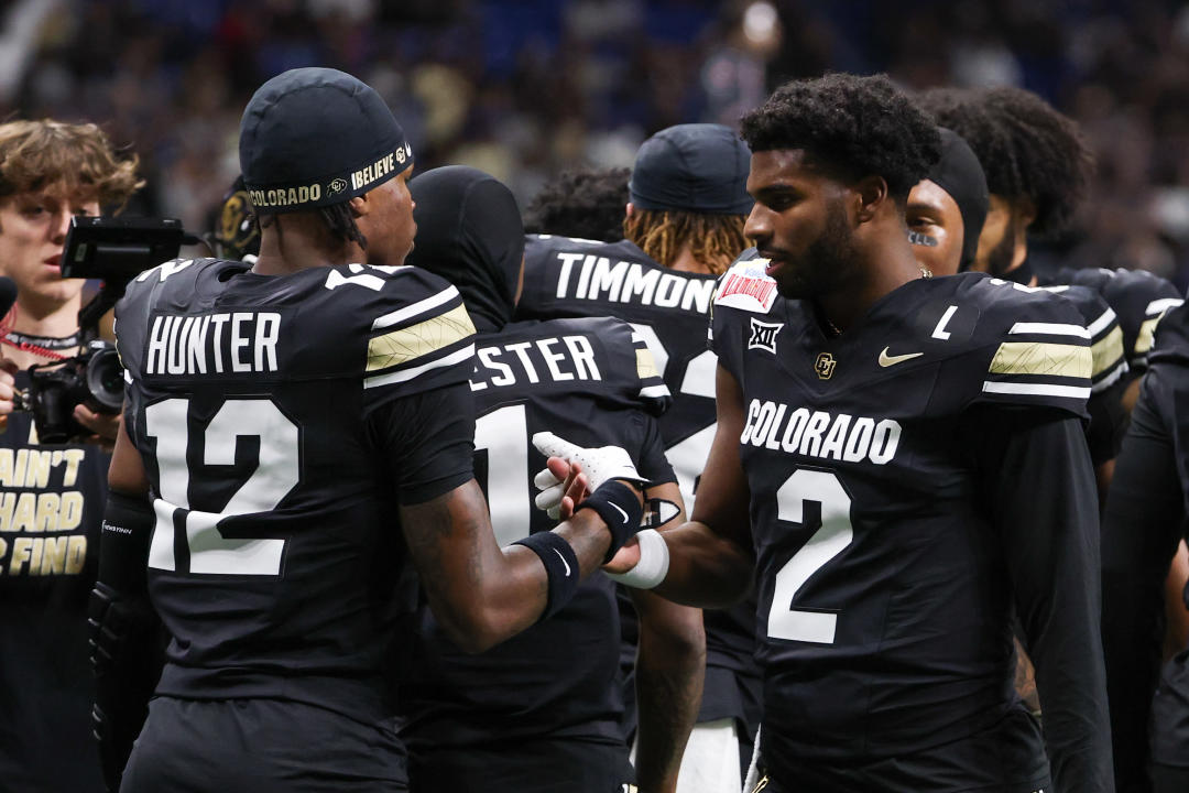 SAN ANTONIO, TX - DECEMBER 28: Colorado Buffaloes quarterback Shedeur Sanders (2) and Colorado Buffaloes wide receiver Travis Hunter (12) high five before the BYU Cougars football game and Colorado Buffalos on December 28, 2024, at the Alamodome in San Antonio, Texas. (Photo by David Buono/Icon Sportswire via Getty Images)