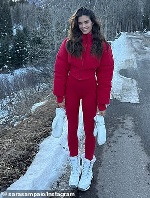 She turned the road into a landing strip, wearing a pair of red tights with a short red puffer jacket, adding contrast with snow-white boots and gloves.