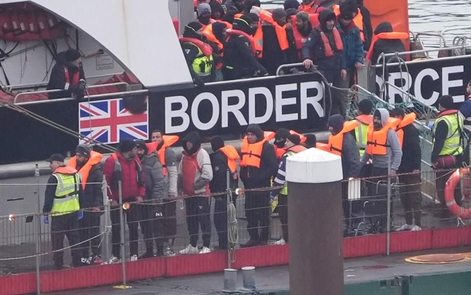 A group of people taken from a small boat in the English Channel last week are brought ashore in Dover.