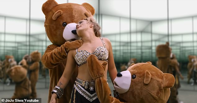 At the beginning of the video, she was wearing the sheer, bedazzled jumpsuit from her previous Karma music video. Then, two giant bears entered the room to help her change her clothes and prepare to face her exes.