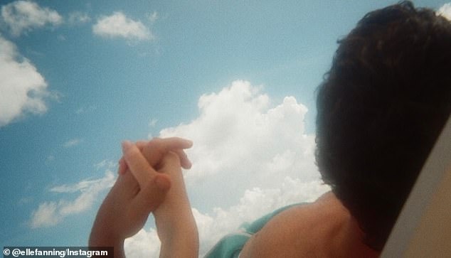 She included a photo she took of her and Gus holding hands while sunbathing on the beach.