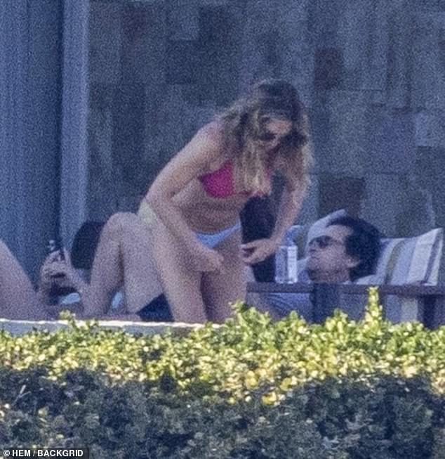 The 55-year-old flaunted her flat stomach in a coral triangle bikini top, paired with blue swimsuit bottoms.