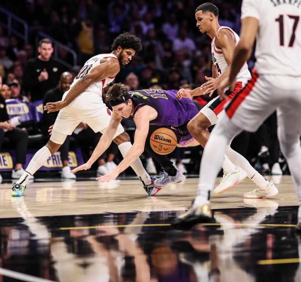 Lakers guard Austin Reaves, center, loses control of the ball.