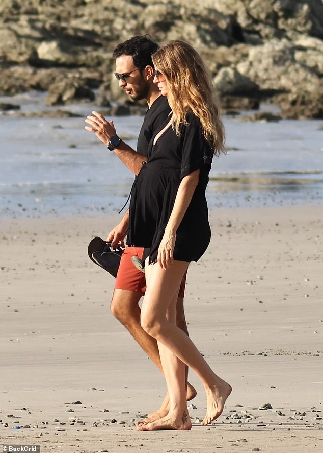 Gisele showed off her belly in a flowing, low-cut black minidress.