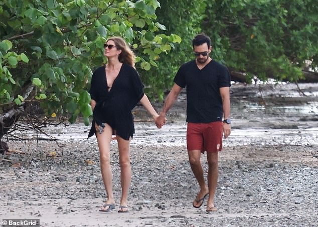 The model and the Jiu-Jitsu instructor held hands while walking on the beach with their dog just before the New Year.