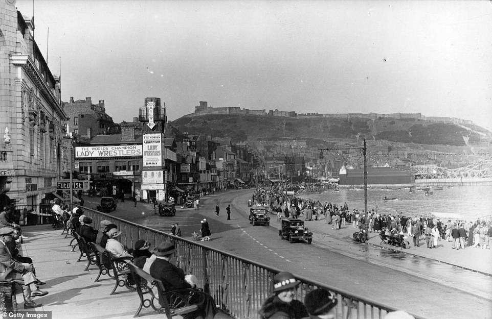 This image shows the Scarborough seafront in 1935. A banner in the background advertises 