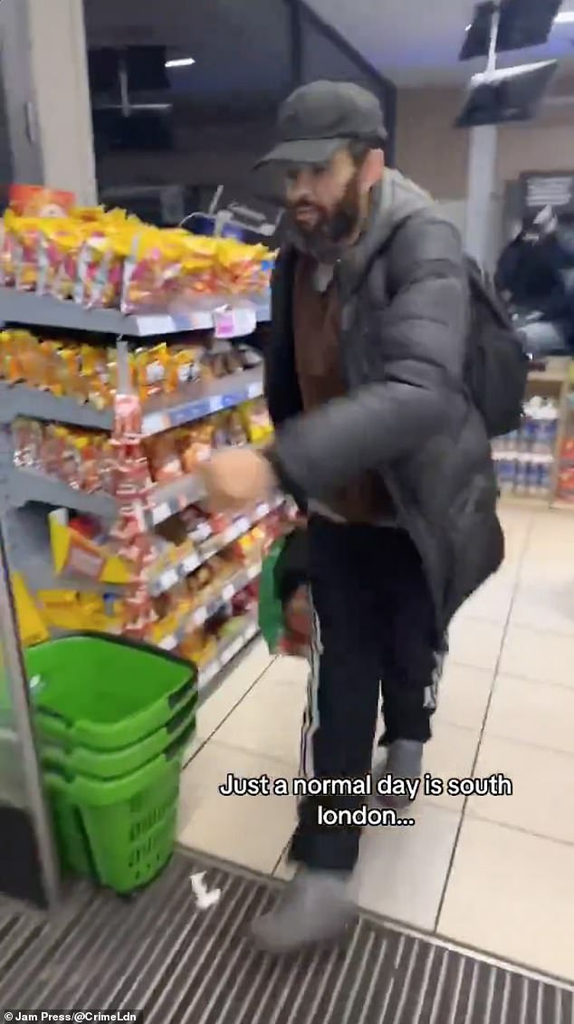 In the video shared online, one of the robbers, pictured, is seen running the store with a bag.