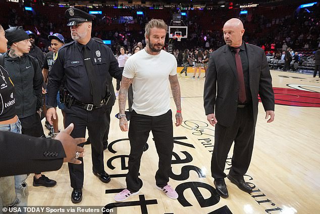 Cutting a great figure, David kept his look simple in a plain white t-shirt which he teamed with black jeans and pale pink Adidas sneakers.