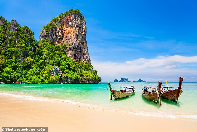 Boats on the beautiful beach with limestone cliffs and crystal clear water in Koh Samui