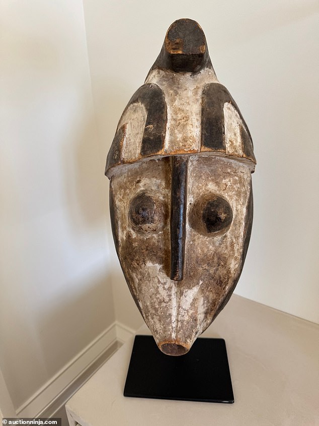 An African wooden face mask on a metal stand costs $20