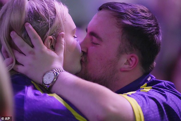 Luke Littler may have a new girlfriend after an unidentified woman spoke into his microphone during a video game livestream. Pictured: Kissing his ex-girlfriend Eloise Milburn at the darts.