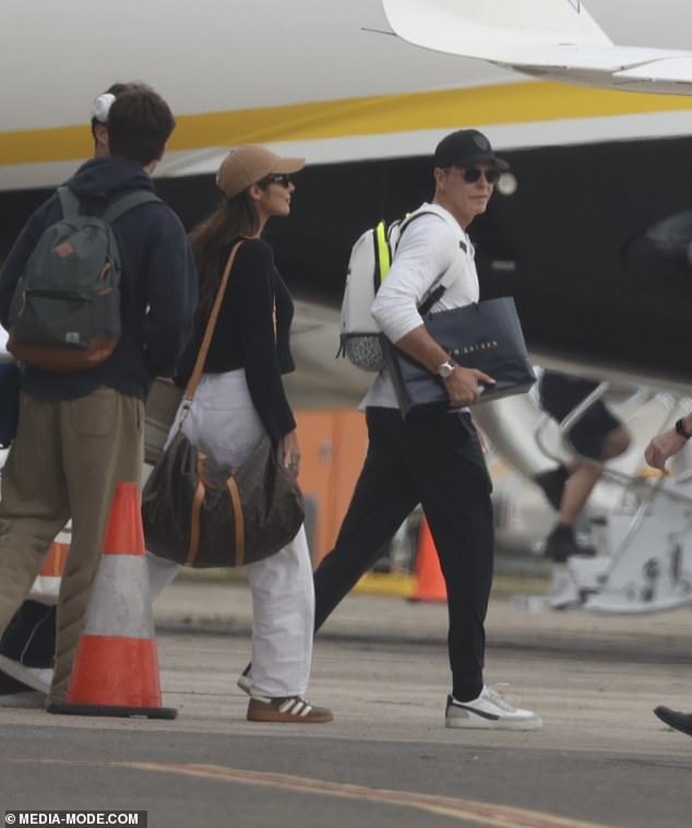 Patrick appeared to have done some high-end designer shopping before boarding while carrying a Ralph Lauren shopping bag in one hand.