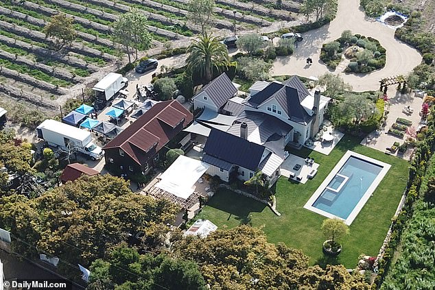 DailyMail.com can reveal that Meghan is not using her own mansion in Montecito, but is instead using the kitchen of philanthropists Tom and Sherrie Cipolla (production trucks and tents are seen on the property).