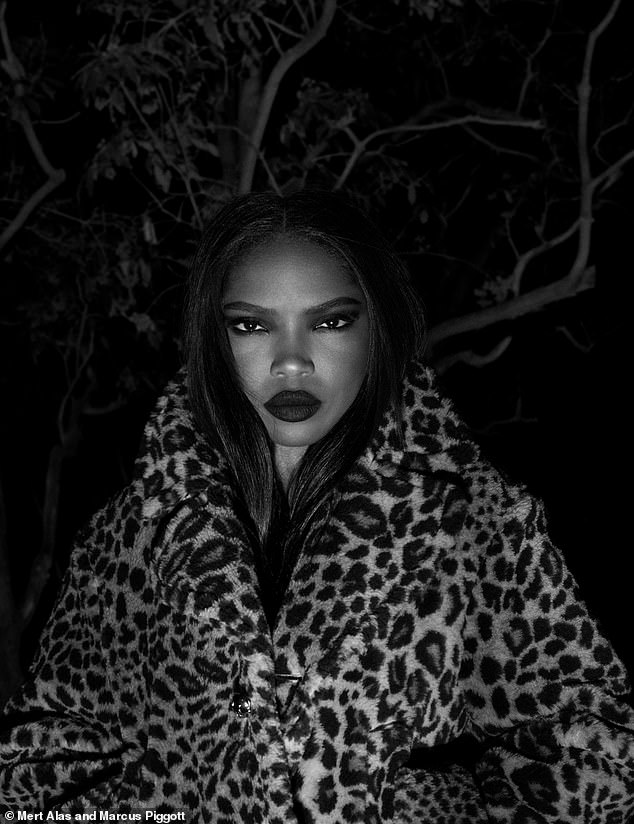 Ryan Destiny posed in a leopard print coat and bold red lipstick