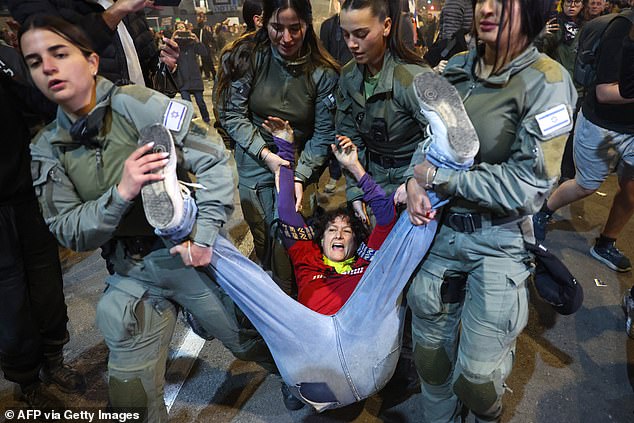 A protester is forcibly removed from outside the IDF headquarters in Tel Aviv.