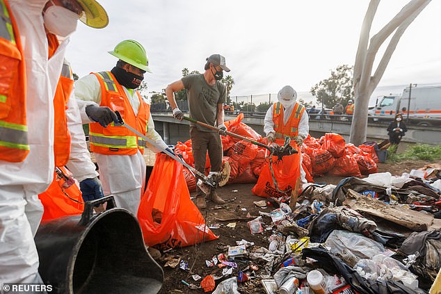 California Governor Gavin Newsom helps clean up a homeless encampment in San Diego, as Democratic officials take a harder line on the problem.