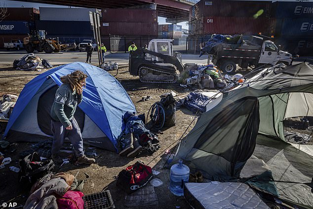 A city work crew arrives at a homeless encampment in Portland, Maine, to clean up tents and people.