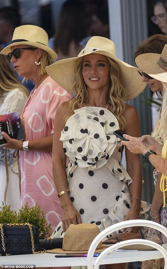 She added a large, floppy straw hat and accented the look with a luxury clutch.