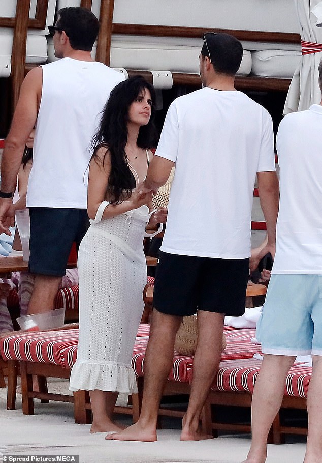 Before entering the water, she was wearing a white sarong-type dress.