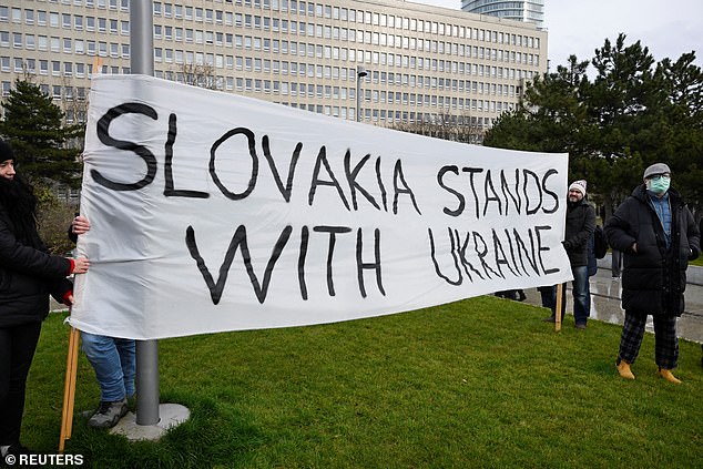 People hold a banner as demonstrators attend an anti-government protest after Slovak Prime Minister Robert Fico met with Russian President Vladimir Putin in Moscow, amid Russia's attack on Ukraine